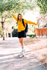 perched young attractive blonde woman with skateboard