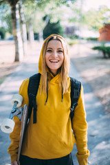 perched young attractive blonde woman with skateboard