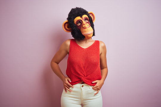 Woman standing wearing t-shirt and monkey mask