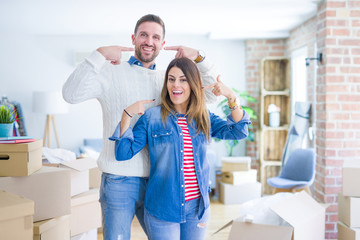 Young beautiful couple standing at new home around cardboard boxes smiling cheerful showing and pointing with fingers teeth and mouth. Dental health concept.