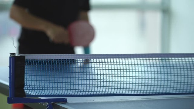Ping pong table, Male playing table tennis with racket and ball in a sport hall