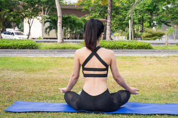 Young beautiful woman practices yoga and meditates outdoor at the mountain. Female doing yoga and...