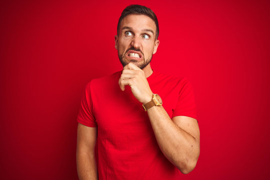 Young handsome man wearing casual t-shirt over red isolated background Thinking worried about a question, concerned and nervous with hand on chin