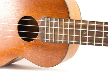 Close-up dark brown wooden ukulele Hawaiian guitar isolated on white background.