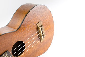 Close-up of dark wooden ukulele music instrument Hawaiian guitar body isolated over white background with copy space. 