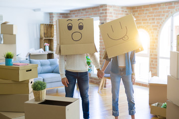 Fototapeta na wymiar Funny couple wearing cardboard boxes with fun crazy emoji faces over head