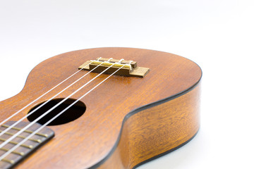 Close-up of dark wooden ukulele music instrument Hawaiian guitar body isolated over white background.