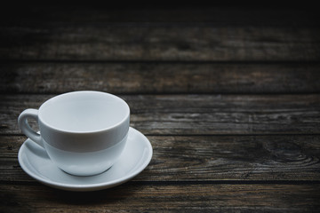 cup of coffee with beans on brown wooden background 