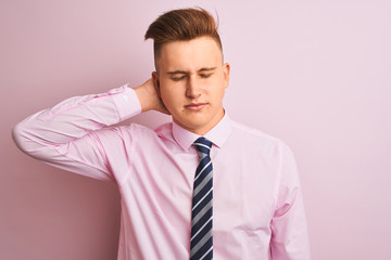 Young handsome businessman wearing shirt and tie standing over isolated pink background Suffering of neck ache injury, touching neck with hand, muscular pain