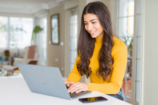 Beauitul young woman working using computer laptop concentrated and smiling