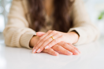 Close up of woman hands on each other wearing a golden alliance for marriage