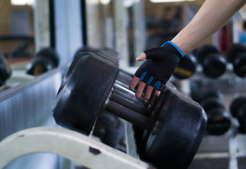 Fototapeta na wymiar Close up hand taking heavy rusty dumbbell to exercise for strength training. sport, fitness, health, lifestyle and people concept