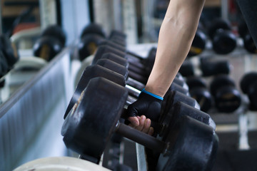 Fototapeta na wymiar Close up hand taking heavy rusty dumbbell to exercise for strength training. sport, fitness, health, lifestyle and people concept
