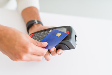 Close up of man hands holding point of sale terminal, dataphone for shopping paying using credit card