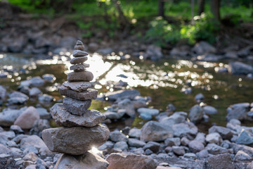 Fototapeta na wymiar zen stone cairn along forest stream