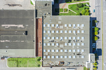 aerial top view of industrial warehouse roof with skylights and ventilation system