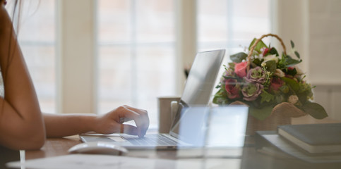 Cropped view of professional businesswoman typing on laptop computer