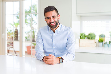 Handsome hispanic business man winking looking at the camera with sexy expression, cheerful and happy face.