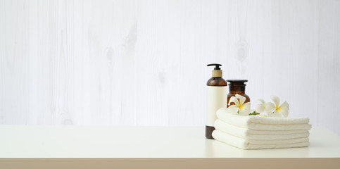 Spa setting with plumeria flower and essential oil bottle