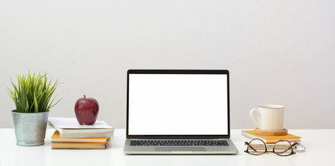 Open blank screen laptop with office supplies and decorations