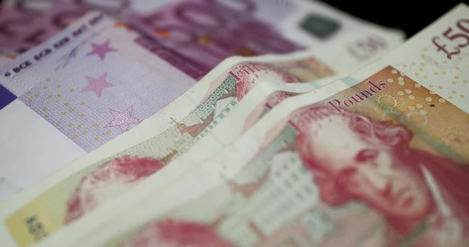 Slow Motion Shot Of Euro And GBP Notes On A Black Table - Parallax Shot Of &euro;500 And &pound;50 Bills - European Currencies - Euro Coin And Great Britain Pound - 4K 30fps