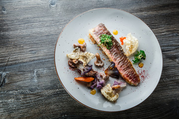 top view on originally decorated baked fish fillet and vegetables