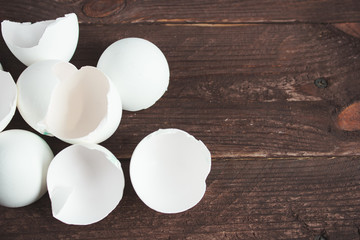 White chicken eggs and shell on a dark wooden background.