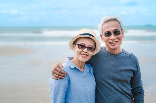 Happy asian couple senior eldery retirement resting at beach honeymoon family together happiness people lifestyle, copy space the left