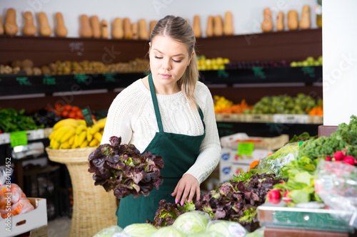 Salesgirl arranging greens
