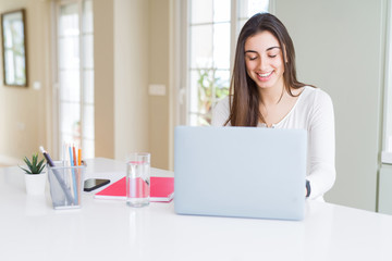 Young beautiful woman smiling happy and working using computer laptop