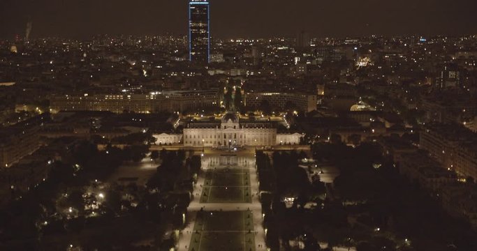 Tilt up of the Southeast Cityscape of Paris, France at Night with the Champ de Mars, École Militaire, Tour Montparnasse and Rooftops viewed from the Eiffel Tower