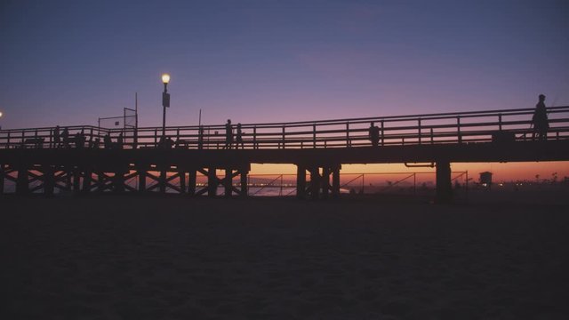 Silhouettes and a pier under beautiful skies.