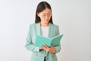 Fototapeta premium Young chinese student woman wearing glasses reading book over isolated white background with a confident expression on smart face thinking serious
