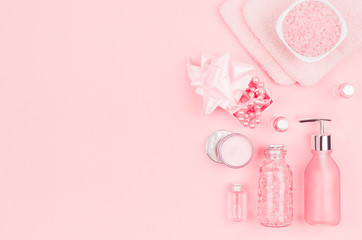 Different cosmetic products and accessories in pink and silver color as decorative border on soft light pink background, copy space, top view.