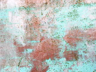 Old iron wall with scratches and rust covered with blue and green and pink paint. Grunge old background.