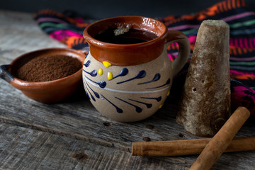 mexican cup of coffee with cinnamon on wooden background