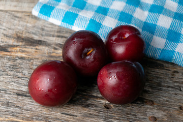 Juicy plums on wooden background