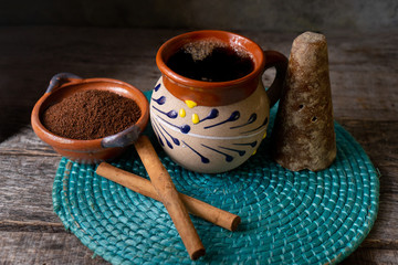 mexican cup of coffee with cinnamon on wooden background