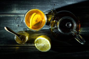 Fresh black tea with lemon and honey in transparent thermostat. Teapot. View from above