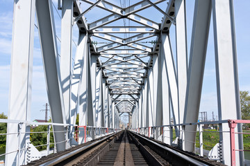 Empty long railway metallic bridge with rails. sunny day