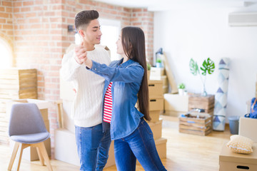 Young asian couple dancing and smiling celebrating moving to a new home