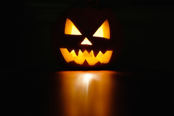 Fototapeta premium Halloween października symbol uroczystości wakacje, straszna dynia świecąca z odbiciem, czarne tło