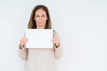 Middle age woman holding blank paper sheet over isolated background with a confident expression on...