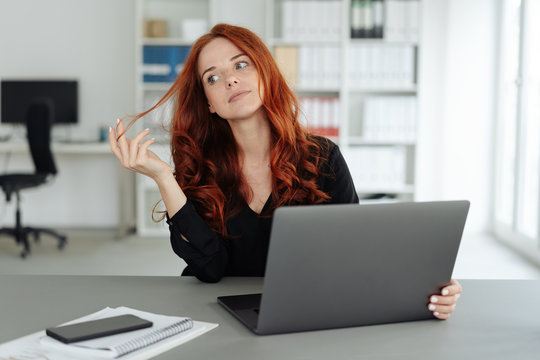 Thoughtful businesswoman twiddling with her hair