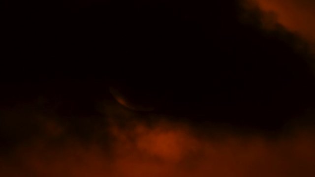 Close up time lapse of sun rising behind dark clouds
