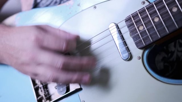 Male hands playing blue t-style guitar