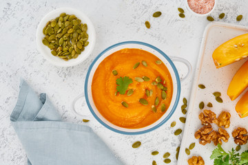 Pumpkin cream soup with seeds, top view light white background