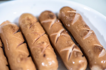 Close Up view of sausages fried in a pan, Sensitive Focus, Macro photo of food being cooked.