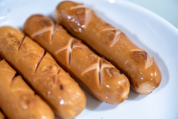 Close Up view of sausages fried in a pan, Sensitive Focus, Macro photo of food being cooked.
