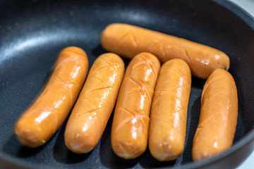 Close Up view of sausages fried in a pan, Sensitive Focus, Macro photo of food being cooked.